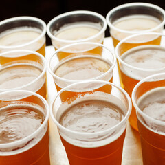 A group of beer glasses with frothy heads on a wooden table