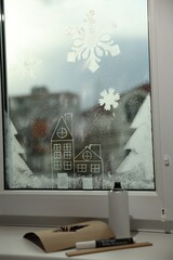 Beautiful drawing made with artificial snow on window at home. Christmas decor