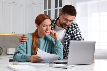 Couple using laptop for paying taxes at home