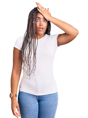 Fototapeta premium Young african american woman with braids wearing casual clothes surprised with hand on head for mistake, remember error. forgot, bad memory concept.