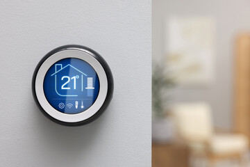 Thermostat displaying temperature in Celsius scale and different icons. Smart home device on white...