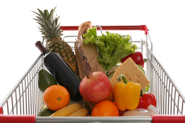 Shopping cart with groceries on white background, closeup