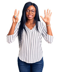 Young african american woman wearing casual clothes and glasses showing and pointing up with fingers number eight while smiling confident and happy.