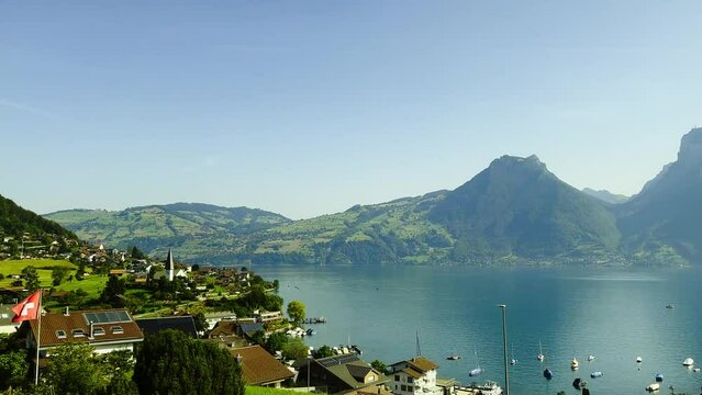 Train Point of View over Beautiful Village Faulensee on Lake Thun with Mountain in a Sunny Summer Day in Bernese Oberland, Bern Canton, Switzerland, Europe