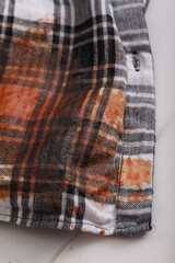 Shirt with stain of sauce on white wooden table, closeup