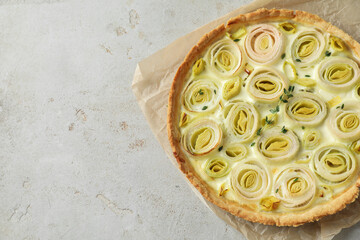 Tasty leek pie on grey textured table, top view. Space for text