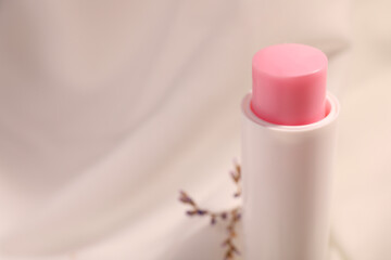 Lip balm against blurred background, closeup. Space for text - obrazy, fototapety, plakaty