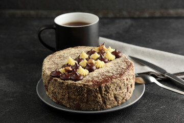 Delicious Kyiv Cake with cream and hazelnuts served on black table
