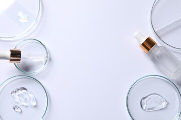Petri dishes with samples of cosmetic serums, pipette and bottle on white background, flat lay. Space for text