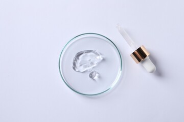 Petri dish with cosmetic serum and pipette on white background, flat lay