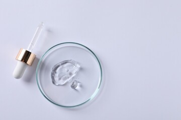Petri dish with cosmetic serum and pipette on white background, top view. Space for text