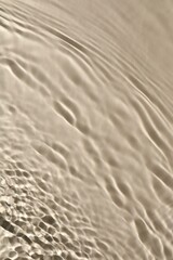 Rippled surface of clear water on beige background, top view