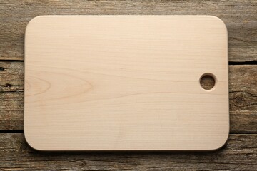 One new cutting board on old wooden table, top view