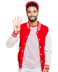 Young man with beard wearing baseball uniform showing and pointing up with fingers number four while smiling confident and happy.