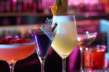 Different fresh alcoholic cocktails on blurred background, closeup