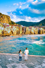 couple of men and woman on vacation in Sicily visiting the old town of Cefalu Sicily Italy, sunset at the beach of Cefalu Sicily, the old town of Cefalu Sicilia Italy - obrazy, fototapety, plakaty