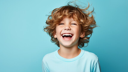 Portrait of a happy young boy on a solid background - obrazy, fototapety, plakaty