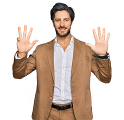 Young hispanic man wearing business clothes showing and pointing up with fingers number nine while smiling confident and happy.