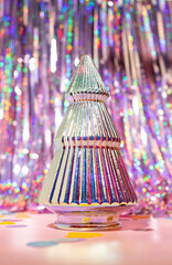 An Iridescent Colorful Christmas Tree on a Foil Party Tinsel Curtain Background