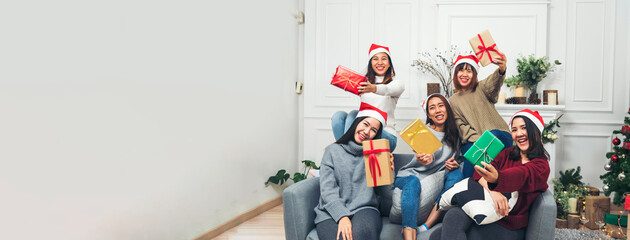 Banner Group of Asian Woman party exchange christmas gift box xmas tree surprise present. Women holding gift box sitting living room celebrate christmas xmas holiday winter festival with copy space - obrazy, fototapety, plakaty
