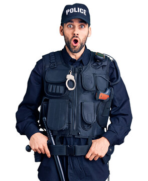 Young handsome man with beard wearing police uniform afraid and shocked with surprise expression, fear and excited face.