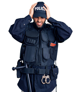Young handsome man with beard wearing police uniform suffering from headache desperate and stressed because pain and migraine. hands on head.
