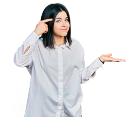 Young brunette woman with blue eyes wearing oversize white shirt confused and annoyed with open palm showing copy space and pointing finger to forehead. think about it.