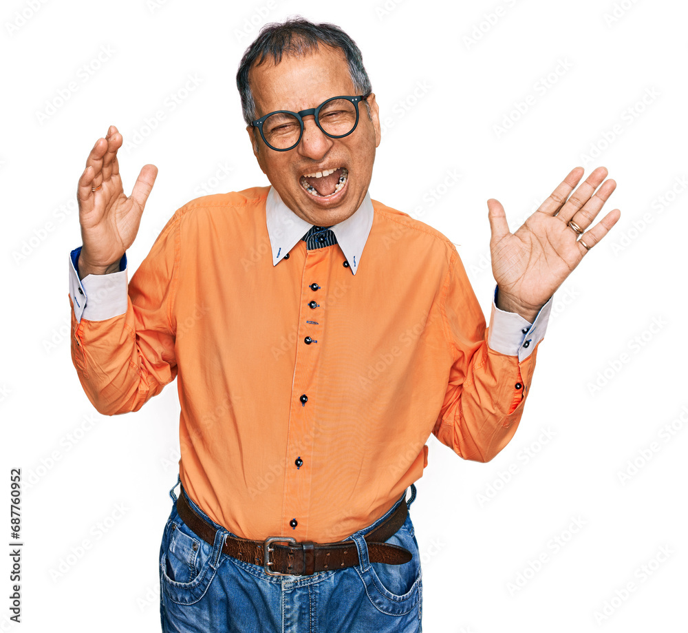 Canvas Prints Middle age indian man wearing casual clothes and glasses celebrating mad and crazy for success with arms raised and closed eyes screaming excited. winner concept