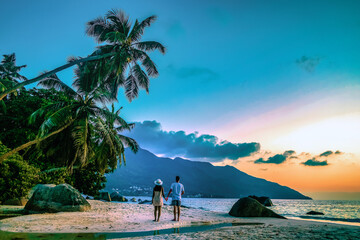 Seychelles tropical islands, Praslin Island Seychelles with couple walking on the tropical beach with palm trees during sunset