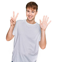 Young caucasian man wearing casual white t shirt showing and pointing up with fingers number seven while smiling confident and happy.