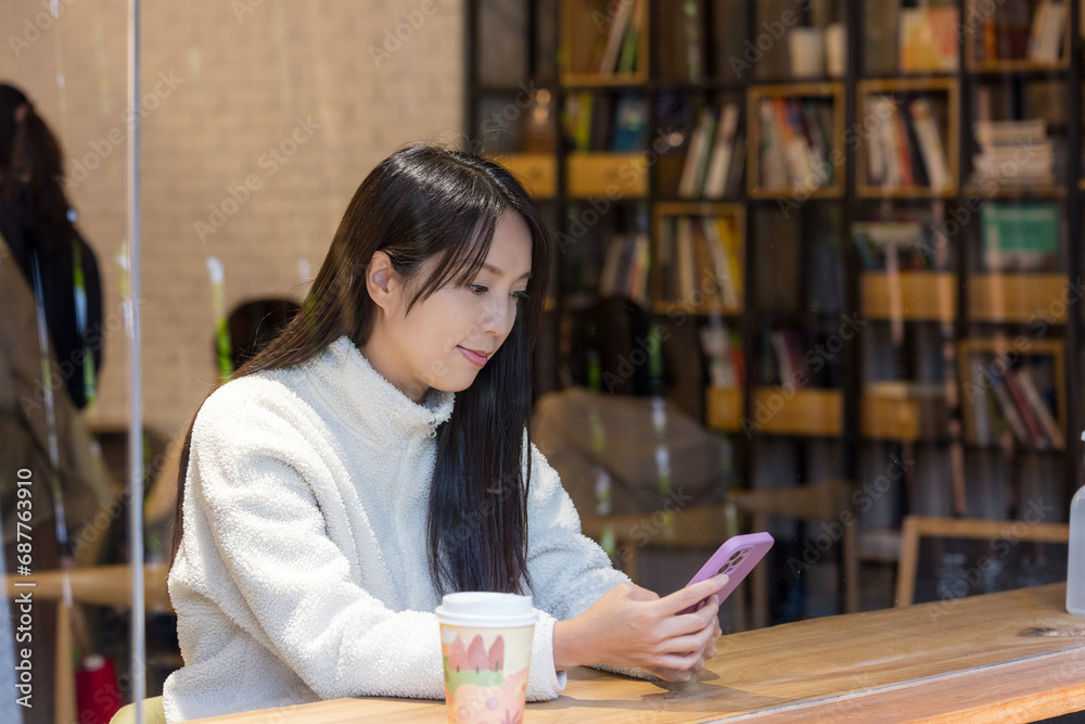 Poster Woman use mobile phone inside coffee shop