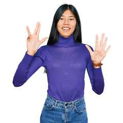 Beautiful young asian woman wearing casual clothes showing and pointing up with fingers number nine while smiling confident and happy.