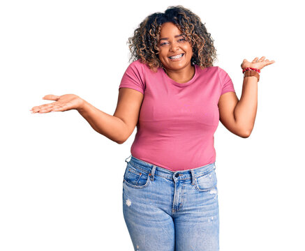 Young african american plus size woman wearing casual clothes clueless and confused expression with arms and hands raised. doubt concept.