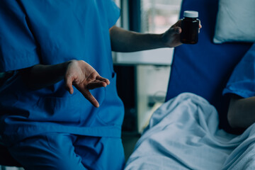 Side view of diverse doctors examining Asian female patient in bed in ward at hospital.