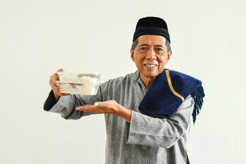 Senior Asian muslim man holding food package for donation or charity