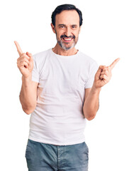 Middle age handsome man wearing casual t-shirt smiling confident pointing with fingers to different directions. copy space for advertisement