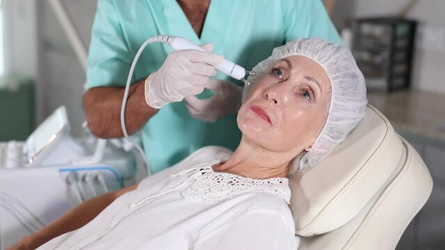Male cosmetic doctor demonstrates RF lifting attachment for skin enhancement of HydraFacial facial skin care machine. High quality 4k footage