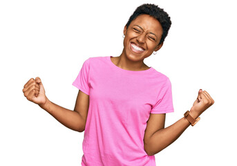 Young african american woman wearing casual clothes very happy and excited doing winner gesture with arms raised, smiling and screaming for success. celebration concept. - Powered by Adobe