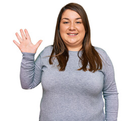 Beautiful brunette plus size woman wearing casual clothes showing and pointing up with fingers number five while smiling confident and happy.