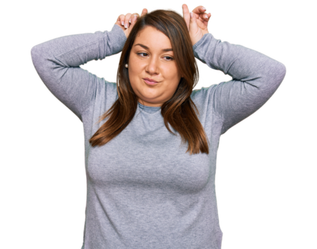 Beautiful brunette plus size woman wearing casual clothes doing funny gesture with finger over head as bull horns