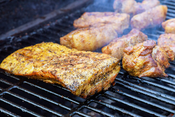 Several pieces pork meat, large bacon roasted at BBQ smoked