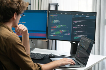 IT developer working online software development on pc monitors at modern home office on coding...