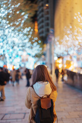 Naklejka premium Traveler with bag visiting Roppongi Hills Christmas Illumination during winter season, happy tourist woman stands on a christmas market in Tokyo, Japan. Travel, holiday and celebrations concept