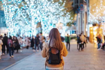 Foto op Aluminium Traveler with bag visiting Roppongi Hills Christmas Illumination during winter season, happy tourist woman stands on a christmas market in Tokyo, Japan. Travel, holiday and celebrations concept © Jo Panuwat D