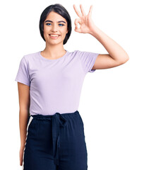 Obraz premium Brunette teenager girl wearing casual clothes smiling positive doing ok sign with hand and fingers. successful expression.