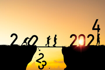 Welcome merry Christmas and happy new year in 2024,Silhouette Men pushing 2023 from cliff and running to 2024 cliff with yellow sky and sunlight in morning time. - obrazy, fototapety, plakaty