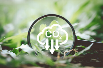 CO2 reducing icon on magnifier glass on green grass for decrease CO2 , carbon footprint and carbon...