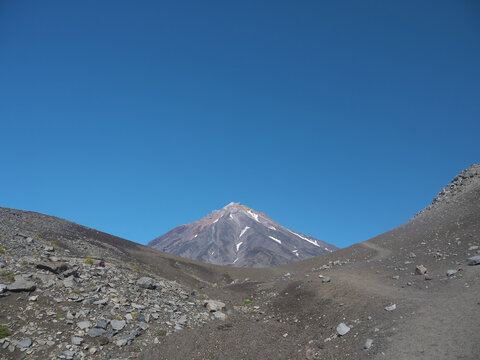 Koryaksy volcano view from Avachinsky pass on sunny day with clear blue sky and hicking trail, famous Kamchatka travel destination