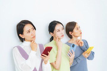 スマホを見ながら考えるミドル女性グループ