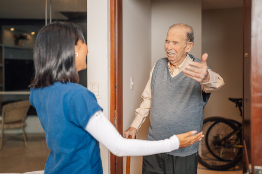 Elderly man greeting as a nurse in a home visit